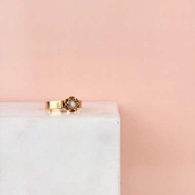 une bague en or posée sur un bloc de marbre blanc
