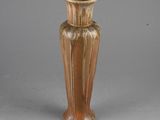 a brown vase that is sitting on a gray surface