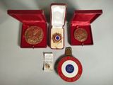 deux médailles d'or et une boîte rouge contenant une médaille