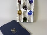 une boîte contenant six cuillères en verre de couleurs différentes