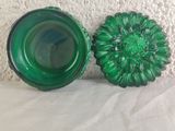 pair of green glass vases sitting on top of a white table