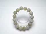 un bracelet composé de perles de jade vert montées sur un support transparent