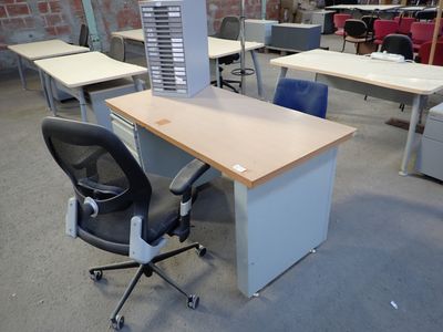 a desk with a chair and a computer on it in an office