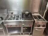 a kitchen with a stove, stove top, and oven