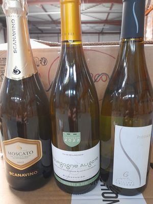 Plusieurs bouteilles de vin sont posées dans une boîte sur une table