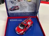a red toy car in a blue box on a table