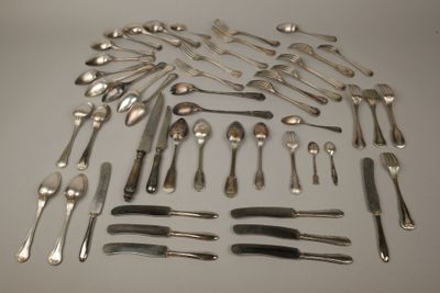 un grand nombre de cuillères et de fourchettes disposées sur la table