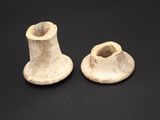 two pieces of pottery sitting on top of a black surface