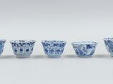 six blue and white cups with designs of birds and flowers