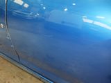 a close up of a blue car with a broken door handle
