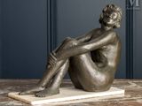 statue of a woman sitting on a marble base