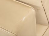 a close up of a white couch with a black cat sitting on it