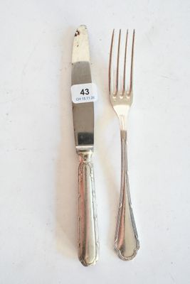 deux fourchettes et un couteau sur une table blanche