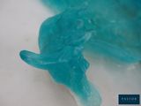 a close up of a blue plastic animal on a white surface