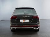 the rear end of a black volkswagen v - cross parked in a white room