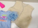 a baby vest, a t - shirt, and a blow dryer sitting on a table