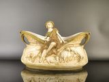 une figurine représentant une femme assise à l'avant d'un bateau