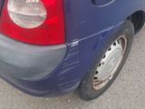 a small blue car parked on the side of the road