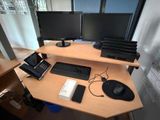 un bureau d'ordinateur sur lequel se trouvent deux écrans et un téléphone