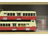 two red and white double decker buses in a box