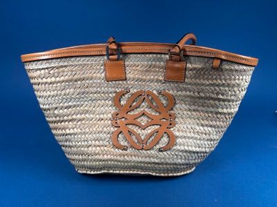 a close up of a straw bag with a brown leather handle