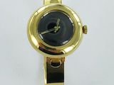 yellow metal watch with black face on a white background