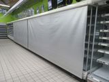 many empty shelves in a store that are covered with tarps