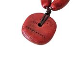 a necklace with a red stone and wooden beads on it