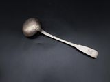a silver spoon with a spoon handle sitting on top of a black surface