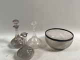 trois vases en verre et un bol posés sur une table