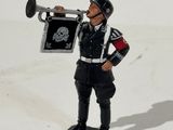 un petit soldat en bois tenant une trompette à la main