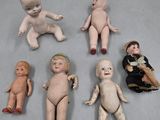 Plusieurs poupées anciennes sont alignées sur une table