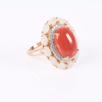a close up of a ring with a red stone surrounded by white stones