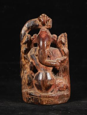 an image of a wooden statue of a man sitting on a tree stump