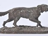 bronze statue of a dog running on a rock on a white background