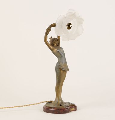 une statue représentant une femme tenant une lampe suspendue à une chaîne
