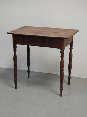 une petite table avec un plateau en bois sur un sol en ciment