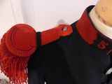 a mannequin dressed in a military uniform with a red hat