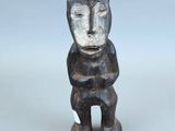 une image représentant une petite statue d'un homme posée sur une surface blanche