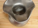 a metal bowl that is on a wooden table