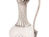 an antique silver plated pitcher with a wavy design on the handle