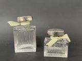 two small glass bottles with a bow on top of them