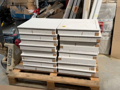 une pile de cartons blancs posée sur une palette dans un entrepôt