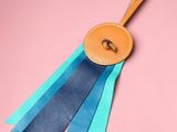 a close up of a blue ribbon with a leather badge on it