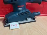 une ponceuse Black & Decker posée sur une table en bois