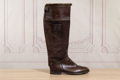 the tall brown boots are sitting on the wooden floor