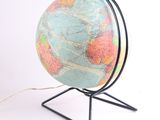 a globe that is on a stand on a white surface