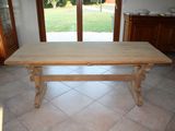 a wooden table in the middle of a tiled floor