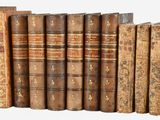 many old books lined up on a shelf together