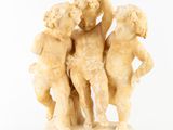 une sculpture en marbre blanc représentant trois chérubins tenant un bébé